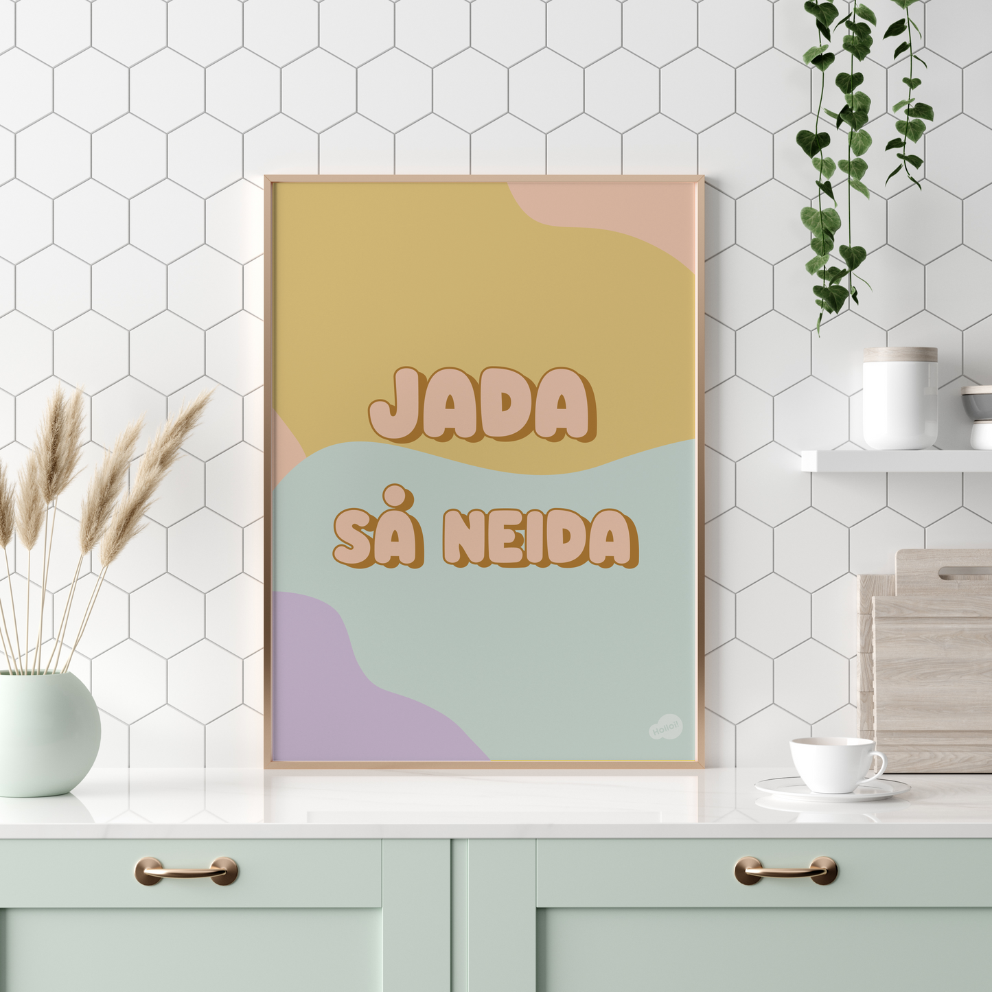 Plakaten '"Jada, så neida" med et artig uttrykk på en bakgrunn av pastellfarger, stående på en kjøkkenbenk