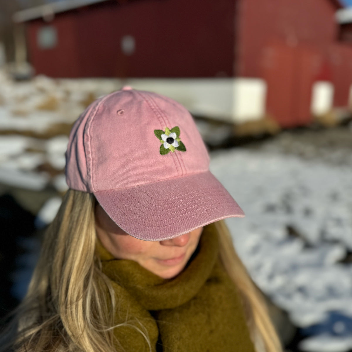 Modell med støvet rosa caps med kaffeblomst, et sommerlig hodeplagg i norsk design