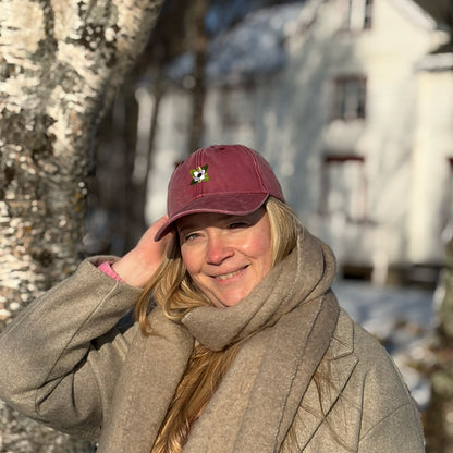 Modell med burgunder caps med kaffeblomst-motiv, et elegant hodeplagg i vasket bomull