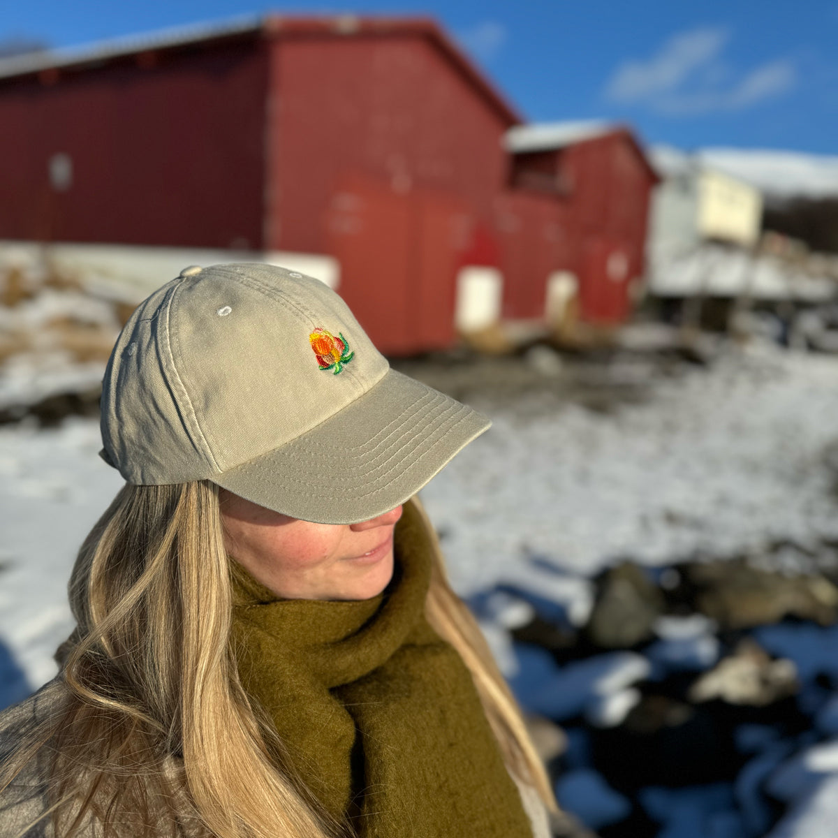 Lys beige multe-caps på en modell som har den på seg utendørs
