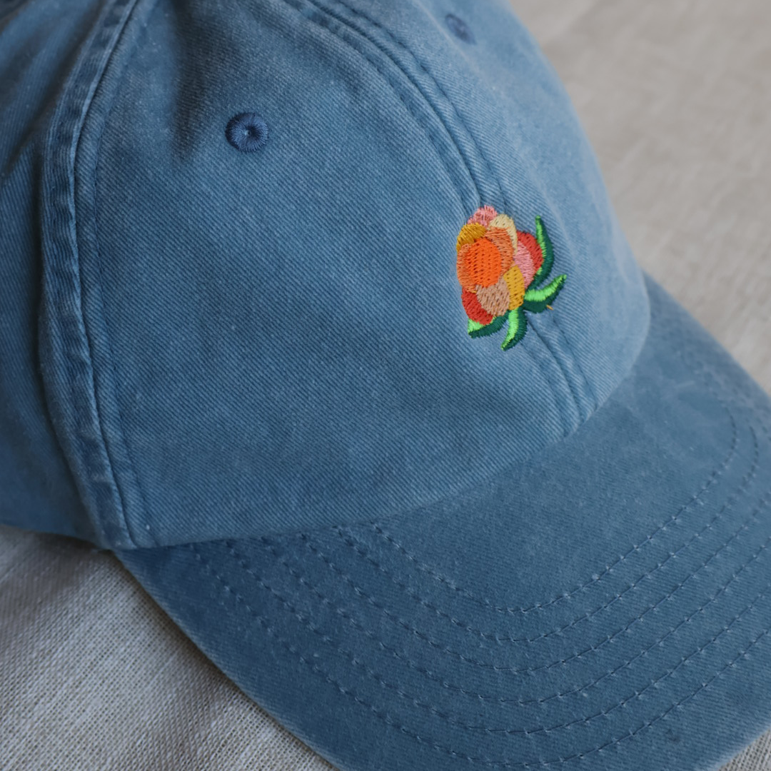Nærbilde av detaljert multe-broderi på vintage blå tekstilbakgrunn