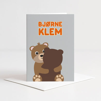 Dobbelt gratulasjonskort fra Holloi med grå bakgrunn og to bjørner som klemmer hverandre med teksten Bjørneklem