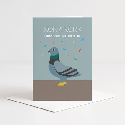 Dobbelt kort fra Holloi i en dus blå farge med illustrasjon av en due og fargerik konfetti, og den nordnorske teksten KORR, KORR KORR GODT DU HOLD DÆ
