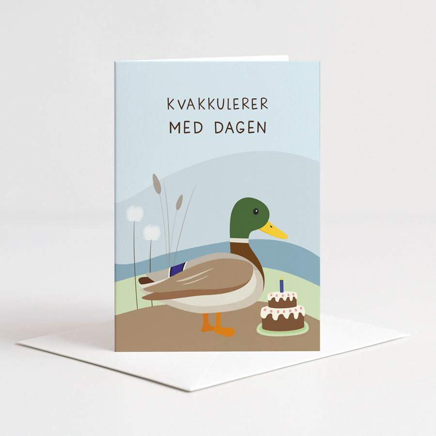 Dobbelt bursdagskort fra Holloi med en illustrasjon av en stokkand ved siden av en bursdagskake, og teksten KVAKKULERER MED DAGEN