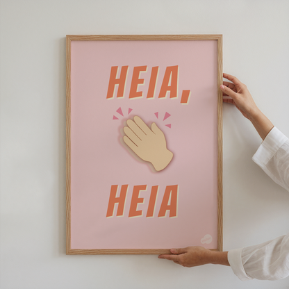 Plakat med motiv av klappende hender og teksten Heia, heia, som holdes av person